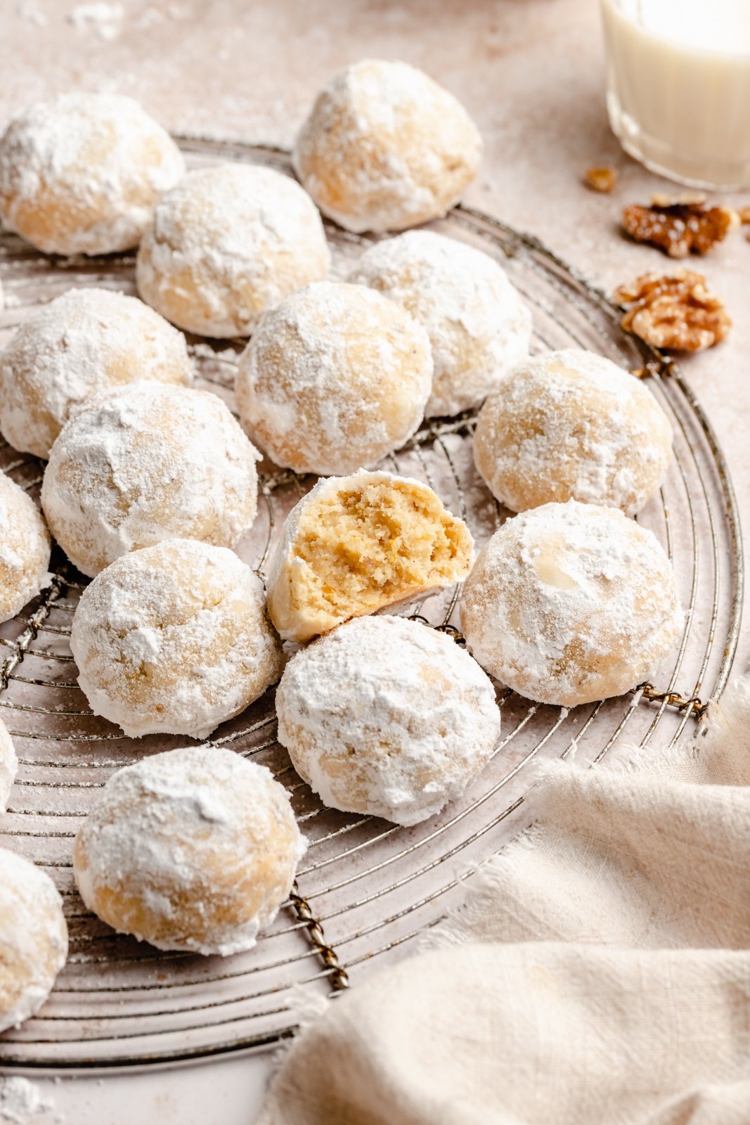 ¡Las galletas de bolas de nieve sin gluten y sin granos que se derriten en la boca, el delicioso crujiente de nueces con nueces! Estas galletas de bolas de nieve suaves y saludables pueden optar por agregar el sabor reconfortante del cardamomo, la canela y la cáscara de naranja. Es excelente con una taza de café Pueden convertirse fácilmente en vegetarianos y son las galletas perfectas para compartir. Galletas de bolas de nieve sin gluten en una rejilla de metal