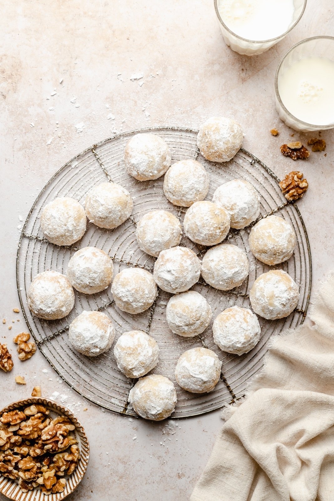 ¡Las galletas de bolas de nieve sin gluten y sin granos más lindas con un delicioso crujido de nueces! Estas galletas de bolas de nieve suaves y saludables se pueden agregar con el sabor reconfortante del cardamomo, la canela y la cáscara de naranja, y también son excelentes con una taza de café. Son fáciles de convertir en veganos y son galletas perfectas para compartir. Galletas de bolas de nieve sobre una rejilla de alambre