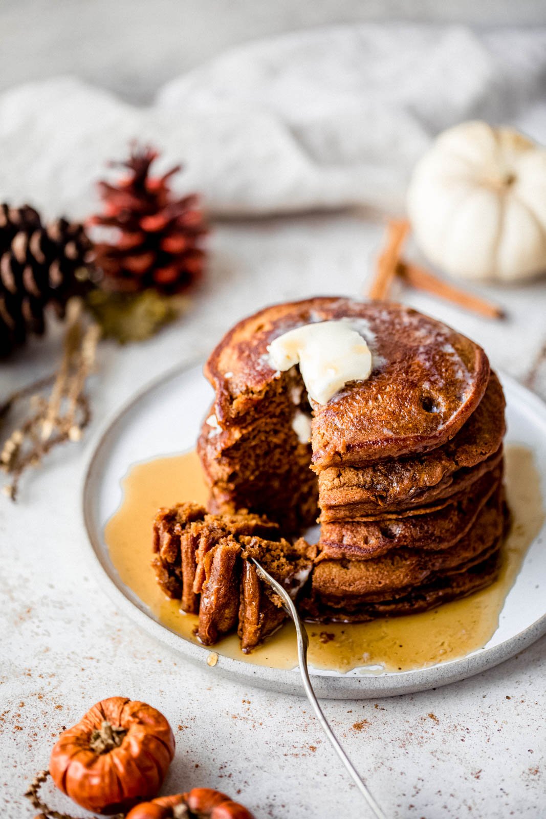 Tortitas de pan de jengibre increíblemente esponjosas hechas con harina de trigo integral, especias calientes y melaza dulce perfecta. Estos panqueques de pan de jengibre más saludables no contienen productos lácteos y están perfectamente condimentados, ¡oh, tan esponjosos, el brunch navideño perfecto! Una pila de panqueques de jengibre en un plato, dale un mordisco