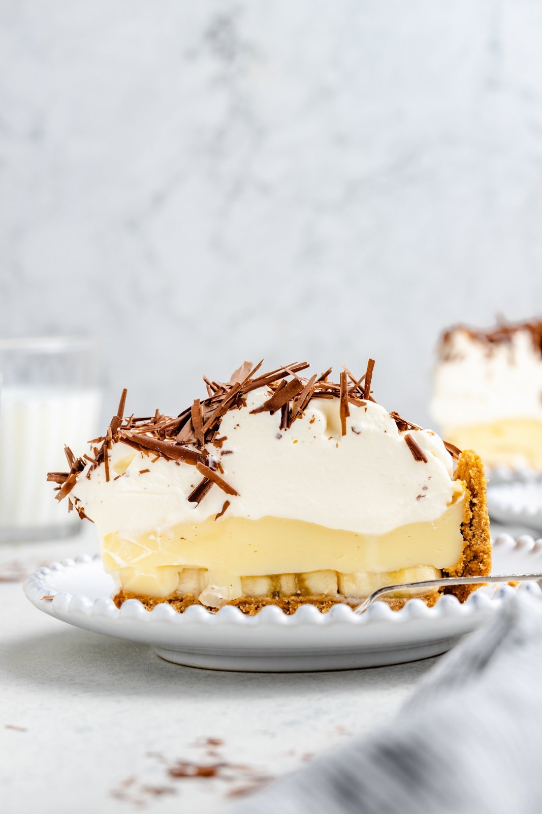 ¡Más de 50 increíbles postres de frutas frescas para hacer durante todo el verano! Estas recetas de postres de frutas son una excelente manera de usar bayas, cítricos, duraznos e incluso plátanos maduros. Perfectas para fiestas de verano y barbacoas, o lo que necesites. . Pastel de crema de plátano en un plato