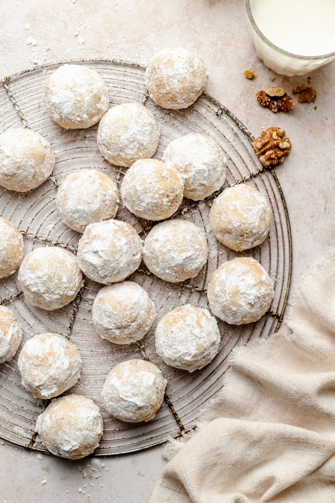 ¡Galletas de bolas de nieve instantáneas sin gluten y sin granos con un delicioso crujido de nueces! Estas galletas de bolas de nieve suaves y saludables se pueden agregar con el sabor reconfortante del cardamomo, la canela y la cáscara de naranja, y también son excelentes con una taza de café. Son fáciles de convertir en veganos y son galletas perfectas para compartir. Galletas de bolas de nieve sin gluten en una rejilla de metal