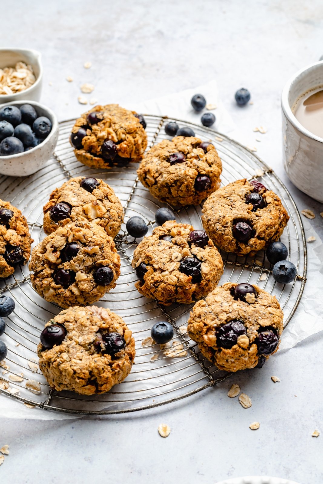 ¡Un plato de galletas de desayuno de arándanos veganas y sin gluten que saben igual que muffins de arándanos! Estas saludables galletas de desayuno de arándanos son naturalmente dulces y están llenas de nutrientes de semillas de chía, lino, avena, nueces y más ingredientes. Perfectas para congelar, ¡Es el desayuno o merienda perfecto para las semanas ocupadas! Galletas de desayuno de arándanos veganas en una rejilla de alambre