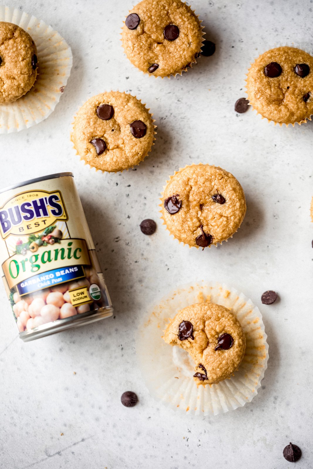Muffins suaves de mantequilla de maní y garbanzos con deliciosas chispas de chocolate en cada bocado. Estos sencillos muffins repletos de proteínas requieren solo 7 ingredientes simples, y la masa se puede preparar directamente en una licuadora o procesador de alimentos. Fácil, congelador Apto para gluten, sin gluten -sin lácteos, perfecto para la hora de la merienda o después del entrenamiento. #muffins #glutenfree #dairyfree #healthysnack #garbanzos Muffins de garbanzos con mantequilla de maní sin harina junto a una lata de garbanzos