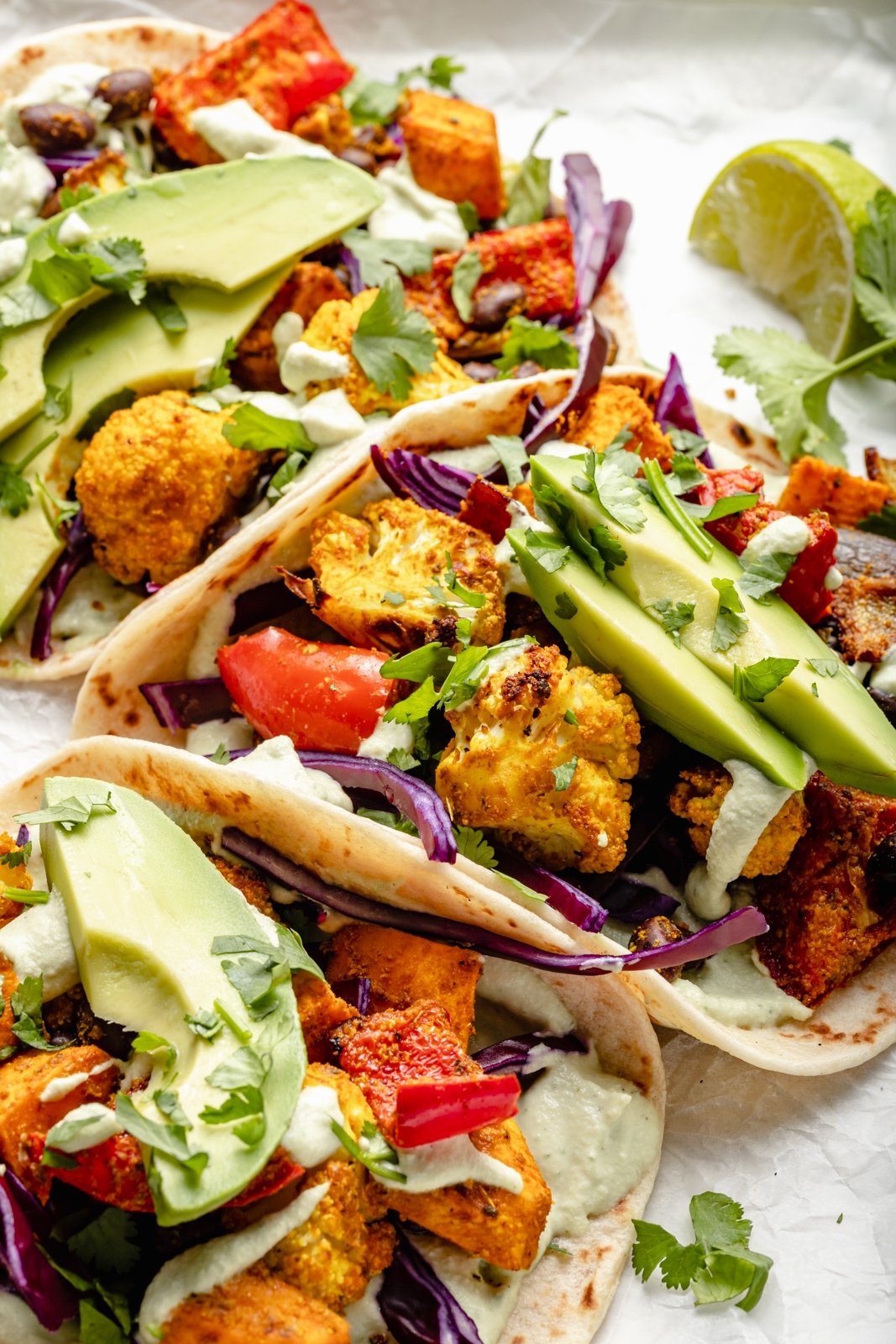 Hermosos tacos de vegetales asados rellenos con vegetales perfectamente sazonados y mucha proteína de origen vegetal. Sirve estos sencillos tacos veganos con aguacate, repollo rojo en rodajas, cilantro fresco y tu elección de dos salsas cremosas y deliciosas. ¡La mejor cena sin carne en una sola sartén! Tacos Veganos con Vegetales Asados y Aguacate