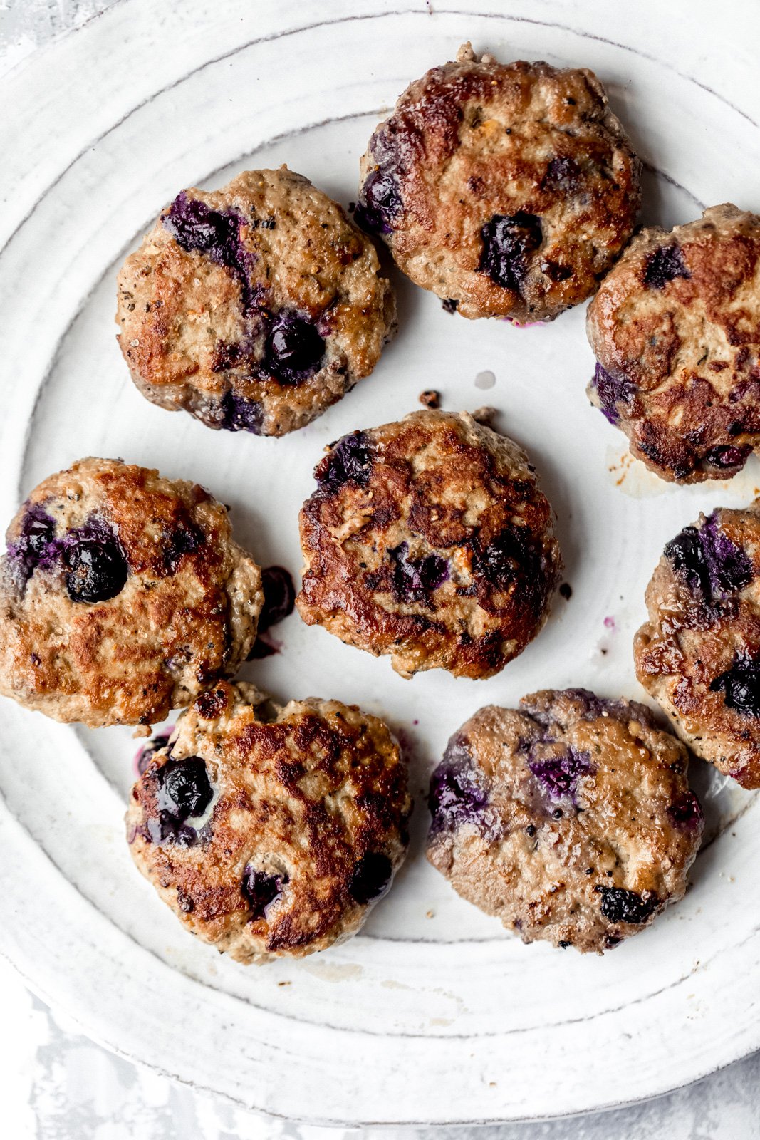 Dulce y salado Paleo Maple Blueberry Turkey Sausage Breakfast Pie con deliciosas especias y jugosos arándanos en cada bocado. ¡Sirve estas increíbles empanadas de salchicha de pavo con huevos fritos para obtener el mejor desayuno rico en proteínas y bajo en carbohidratos! Pastel de salchicha de pavo y arándanos en un plato