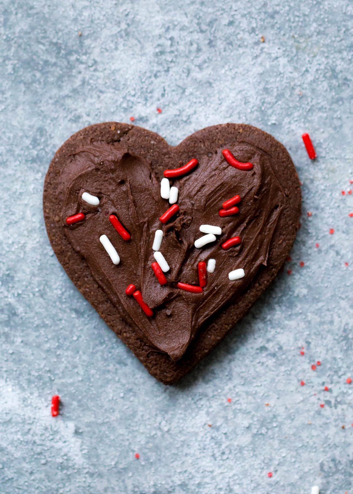 Deliciosas galletas de azúcar con chocolate y harina de almendras que no contienen cereales ni gluten. ¡Esta receta fácil de galletas de un tazón se puede cortar o enrollar en masa! Cubra con glaseado de chocolate sedoso y aterciopelado si lo desea. Galletas De Azúcar De Chocolate Con Harina De Almendras Cortadas En Forma De Corazón