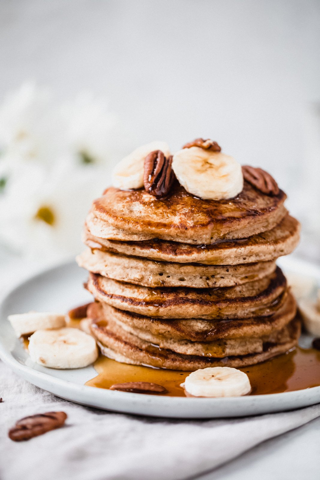 Recetas deliciosas y fáciles de plátano maduro para cada ocasión de merienda y postre. Encontrará recetas saludables con bananas, refrigerios indulgentes y formas únicas de usar bananas demasiado maduras en abundancia. ¡Incluye consejos para batidos, panes, panqueques, galletas e incluso plátanos congelados! Montón de tortitas de plátano en un plato