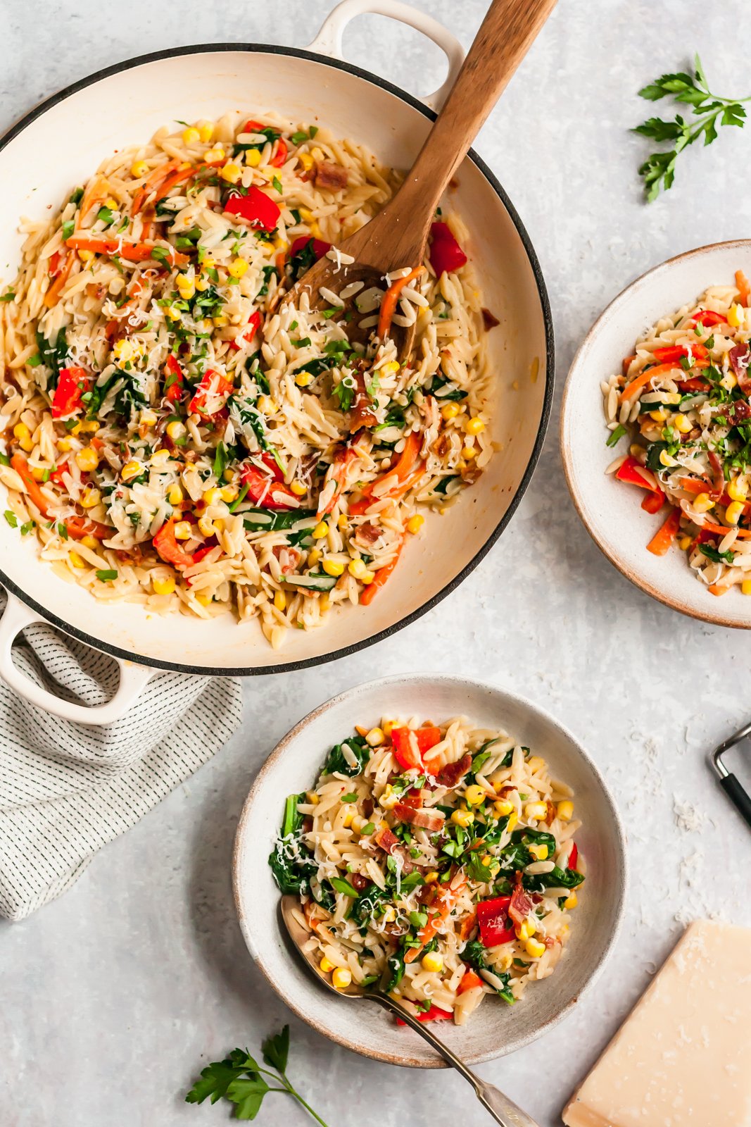 ¡Más de 40 de las mejores y deliciosas recetas de espinacas! Encontrarás recetas de espinacas para cada comida, incluidos batidos, sopas, pastas y, por supuesto, ensaladas que usan mucha espinaca. Guarda estas recetas únicas y fáciles de espinacas. Es hora de que tengas ¡una bolsa fresca para su próximo uso! Orzo de ajo, parmesano y espinacas en una sartén y un tazón