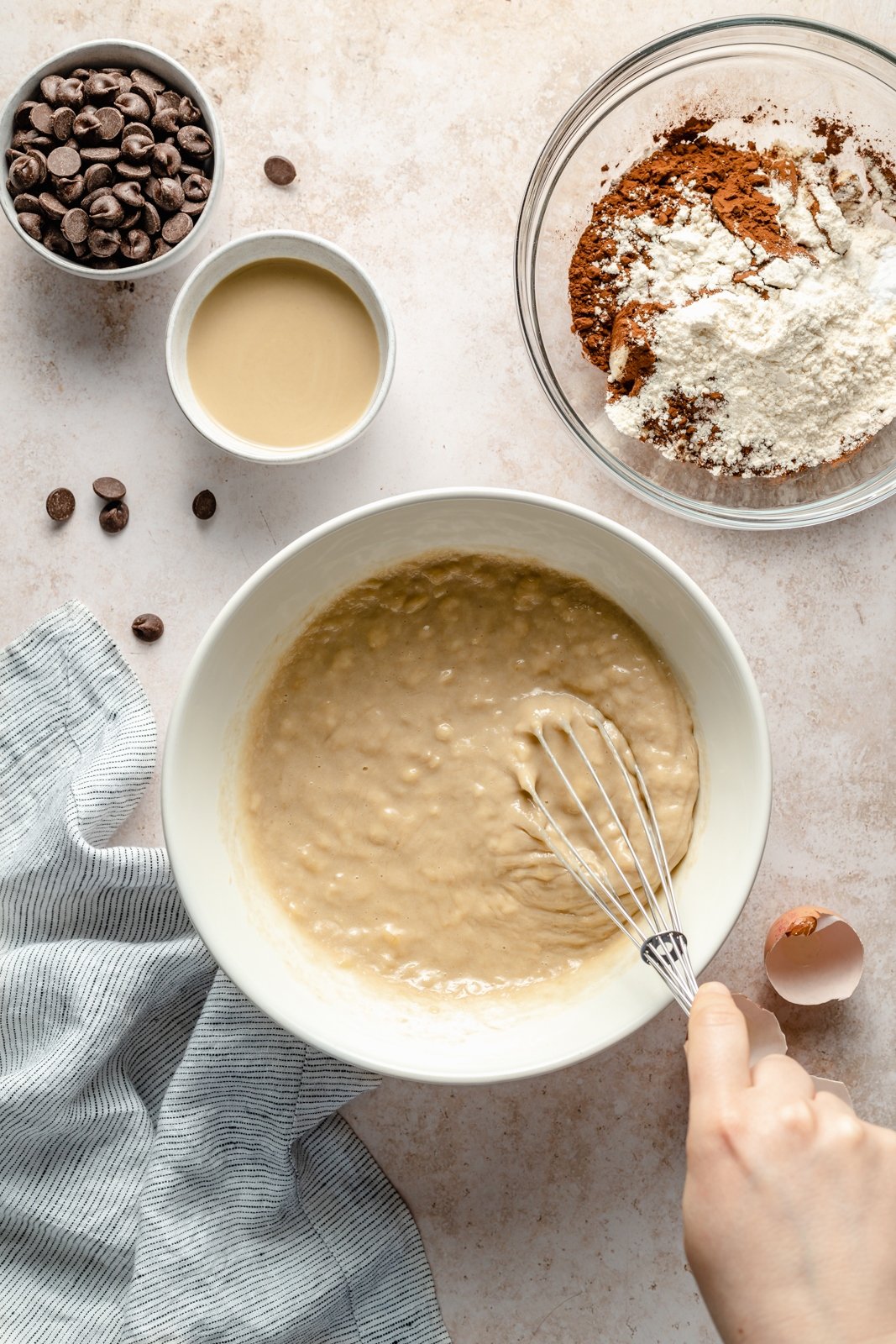 ¡Deliciosos muffins de plátano y chocolate con doble chocolate y tahini que saben a postre! Estos muffins de plátano y chocolate sin granos resultan ser Paleo, sin lácteos, sin gluten, endulzados de forma natural y perfectos para el desayuno o la merienda. Ingredientes húmedos mixtos para muffins de plátano y chocolate sin granos