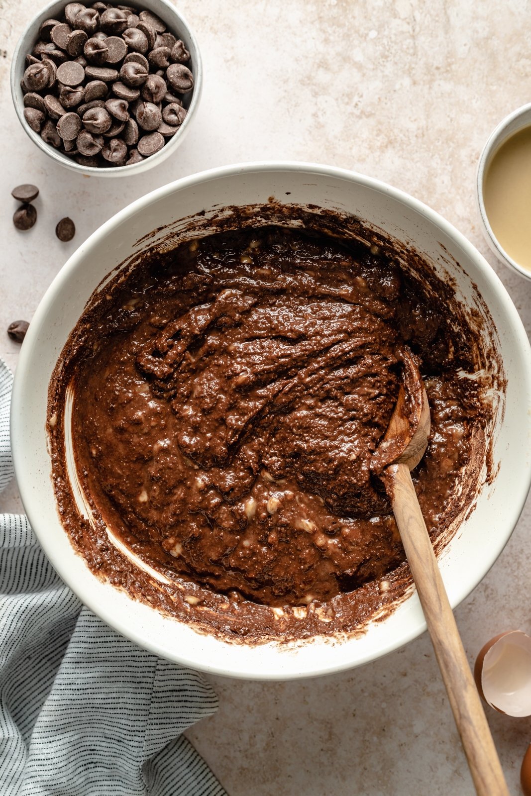¡Deliciosos muffins de plátano y chocolate con doble chocolate y tahini que saben a postre! Estos muffins de plátano y chocolate sin granos resultan ser Paleo, sin lácteos, sin gluten, endulzados de forma natural y perfectos para el desayuno o la merienda. Masa para muffins de plátano y chocolate con tahini en un tazón