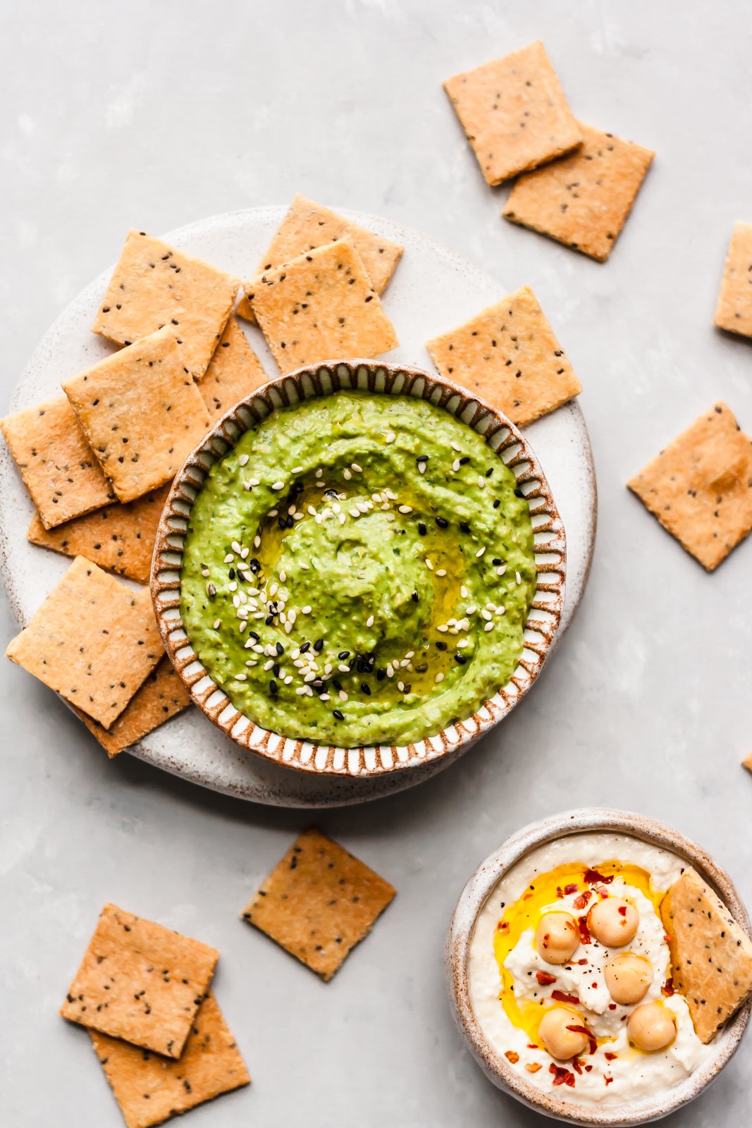 Bocadillos saludables ricos en proteínas, ¡perfectos para viajar o simplemente para llevar! Repletos de ingredientes saludables, estos tentempiés caseros están repletos de fibra y proteínas para que se sienta lleno y satisfecho. Galletas paleo junto a dos tazones de hummus
