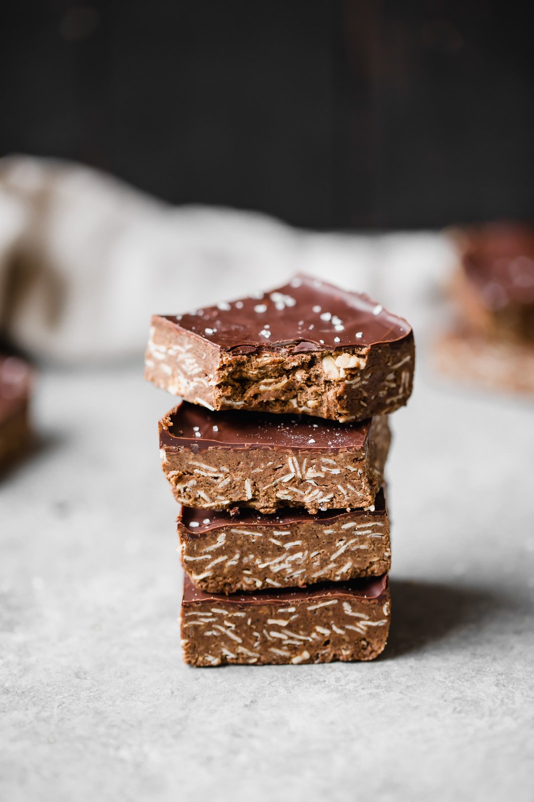 Increíbles barritas de proteína de chocolate y mantequilla de anacardo sin hornear espolvoreadas con sal marina. Estas deliciosas barritas son un delicioso refrigerio para después del entrenamiento y una delicia satisfactoria. Barras de proteína de chocolate apiladas