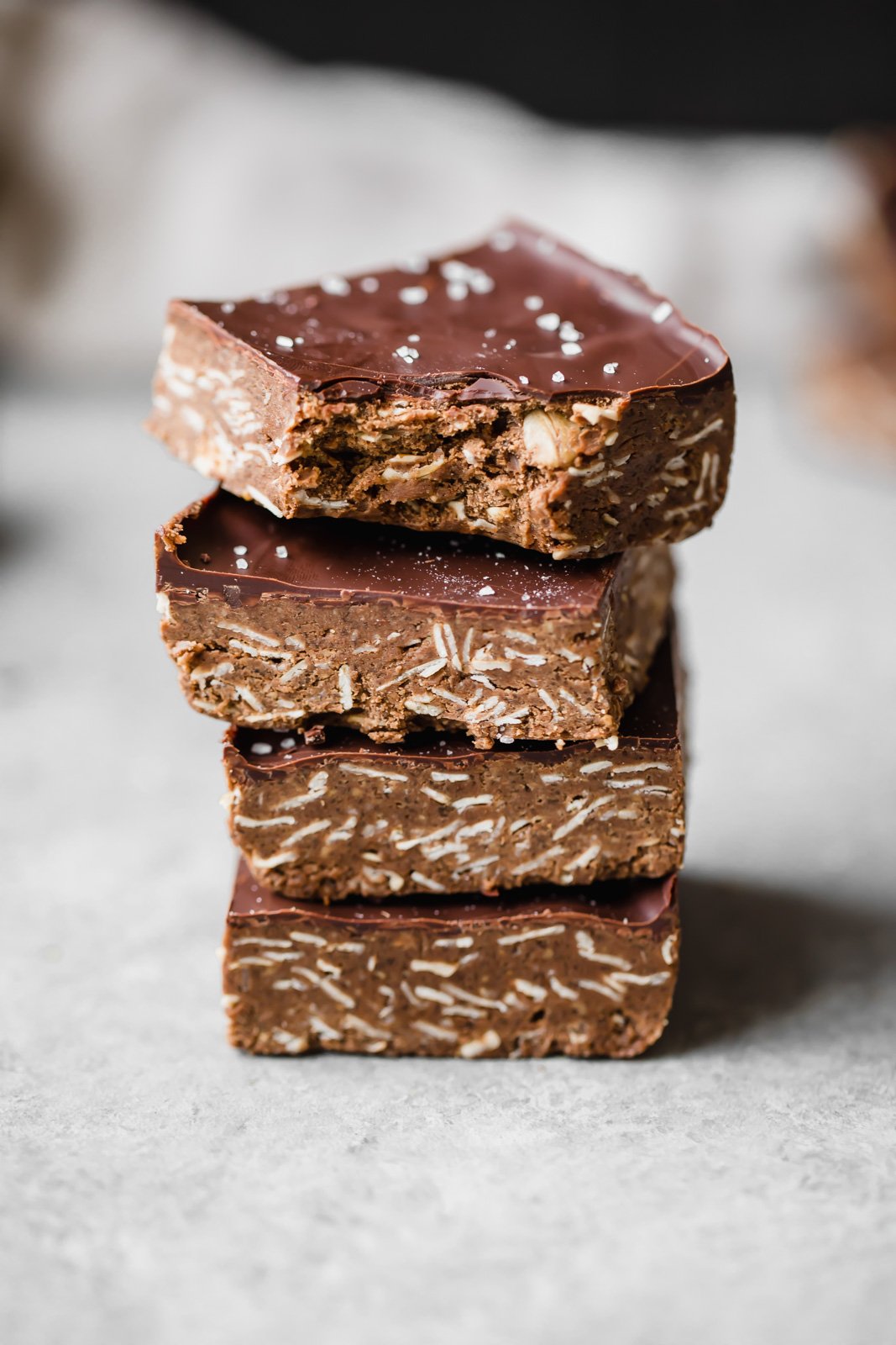 Increíbles barritas de proteína de chocolate y mantequilla de anacardo sin hornear espolvoreadas con sal marina. Estas deliciosas barritas son un delicioso refrigerio para después del entrenamiento y una delicia satisfactoria. Barras de proteína de chocolate apiladas