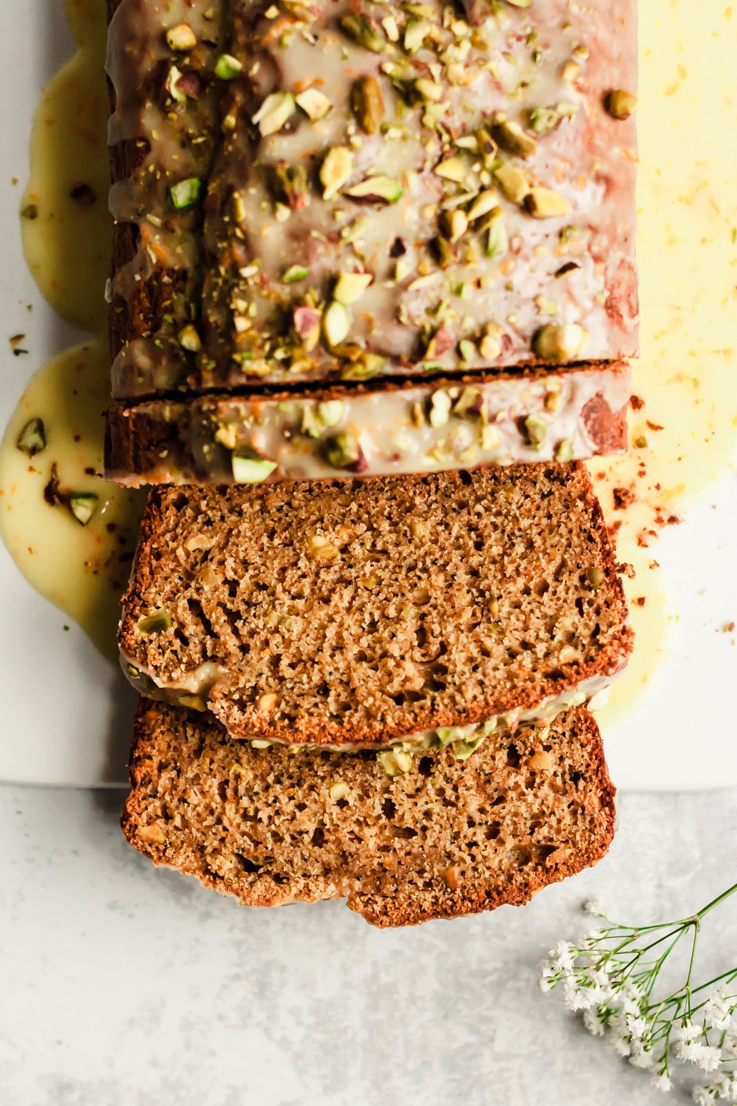 Magnífico pan de yogur de naranja con semillas de amapola y pistacho, endulzado naturalmente con miel, jugo de naranja fresco y rociado con el jugo de naranja dulce perfecto. ¡Pan de yogur delicioso y saludable para la primavera! Yogur de naranja en rodajas en una tabla para cortar foto cenital de pan