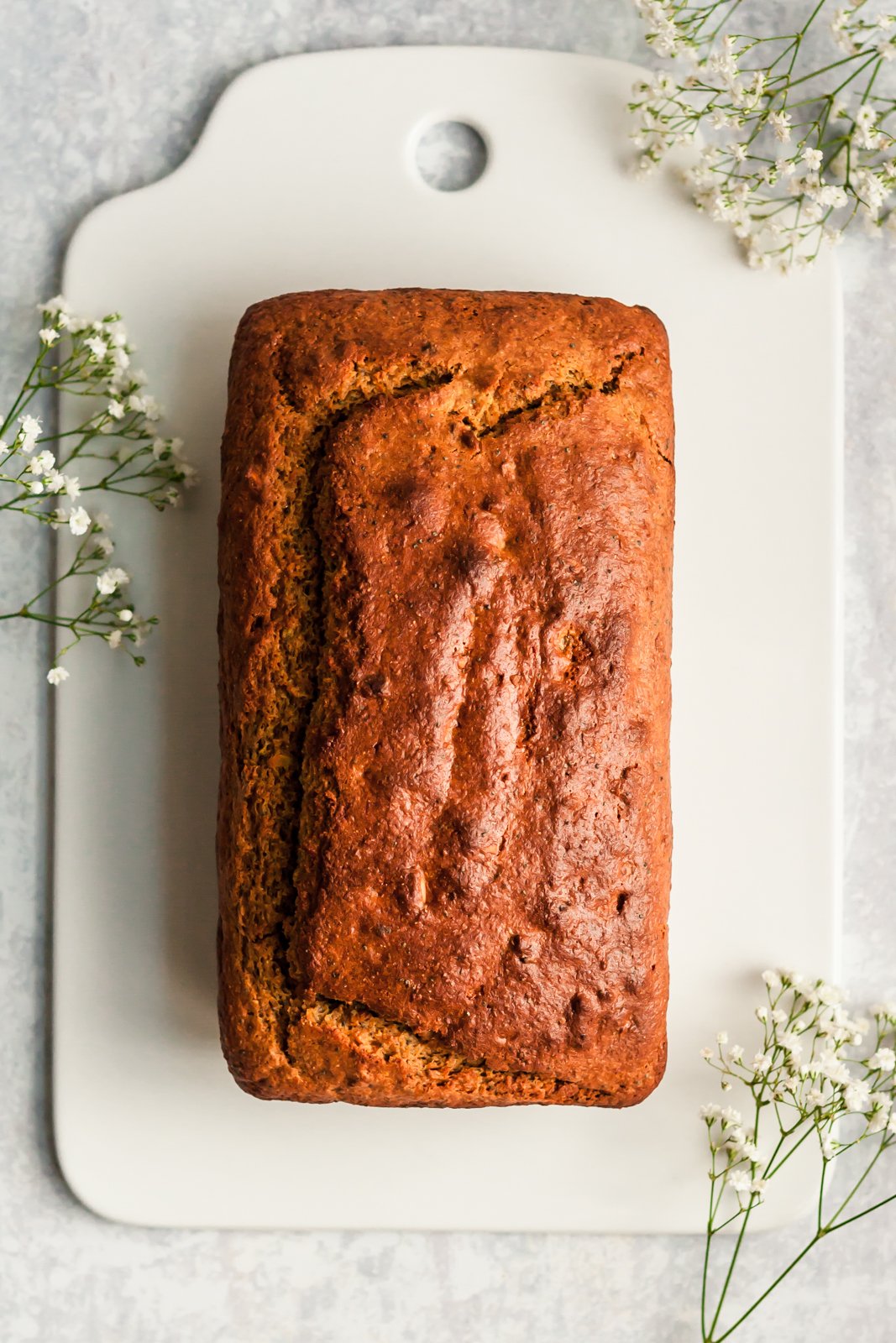 Magnífico pan de yogur con pistacho, semillas de amapola y naranja, endulzado naturalmente con miel, jugo de naranja fresco y rociado con el perfecto jugo de naranja dulce. ¡Delicioso y saludable pan de yogur para la primavera! Pan de yogur con naranja en una tabla para cortar