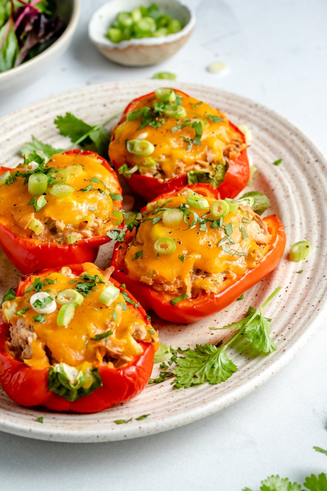 ¡Delicioso chile relleno de atún bajo en carbohidratos mezclado con verduras, yogur griego y salsa de búfalo y cubierto con una capa de queso derretido! Estos sencillos pimientos rellenos de atún son el almuerzo perfecto para combinar con tu guarnición favorita o incluso con un refrigerio rico en proteínas para después del ejercicio. Chili relleno de atún sin gluten en un plato