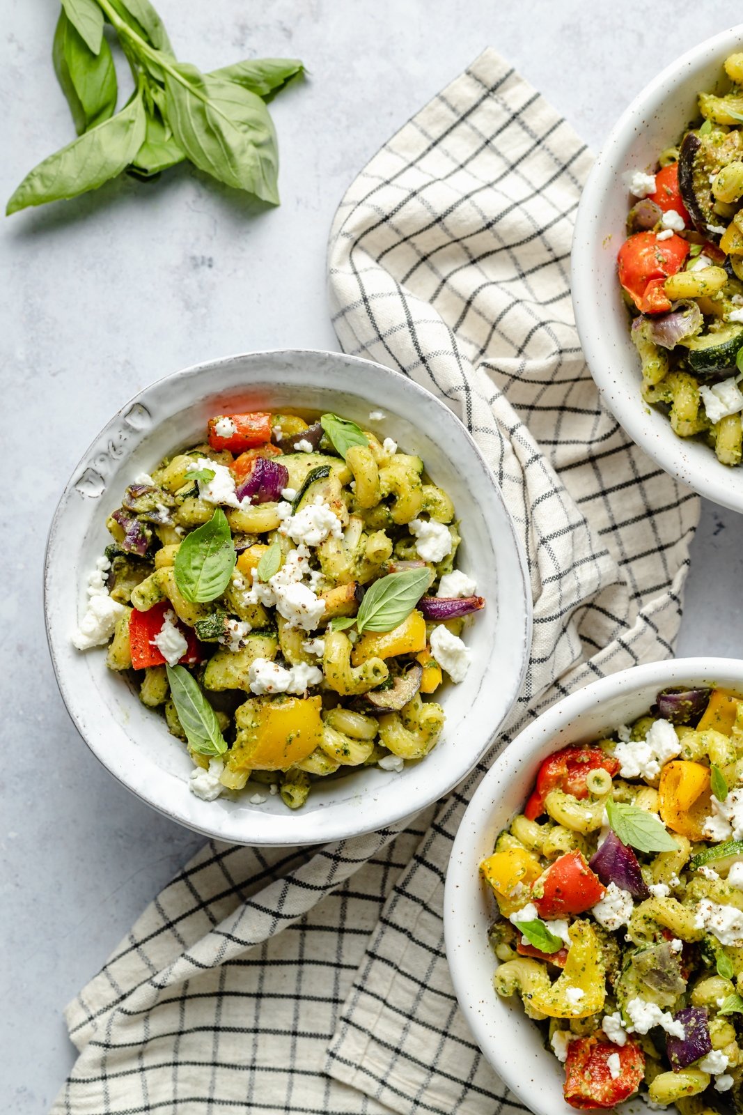 Pasta brillante y deliciosa con verduras asadas servida con un delicioso pesto casero de marañón y queso cremoso de cabra. Esta receta fácil de pasta de vegetales asados presenta vegetales frescos y coloridos que se pueden servir calientes o fríos como ensalada de pasta. ¡Opción para asar verduras y agregar tu proteína favorita! Pasta Saludable de Verduras Asadas con Queso de Cabra en un Tazón
