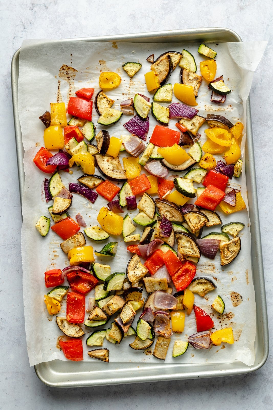 Pasta de verduras asadas brillante y deliciosa con un delicioso pesto casero de anacardos y queso de cabra cremoso. Esta receta fácil de pasta de verduras asadas presenta verduras frescas y coloridas y se puede servir caliente o fría como ensalada de pasta. Opcional para asar verduras y agregar su proteína favorita! Verduras asadas en una sartén para pasta de verduras asadas