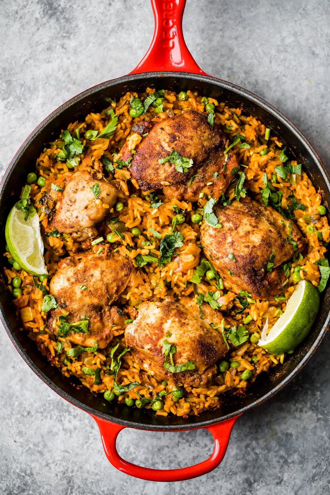 El famoso pollo y arroz puertorriqueño de mi mamá, también conocido como arroz con pollo, está hecho con sofrito de pollo sazonado con adobo casero y delicioso arroz en una sola sartén. Este plato reconfortante es fácil de preparar y es la comida nutritiva perfecta entre semana. ¡Harás esta receta una y otra vez! #arrozconpollo #chickendinner #chickenrecipe #skilletdinner #dinnerideas #healthydinner Pollo Puertorriqueño y Arroz en Sartén, Adornado con Cilantro y Limón