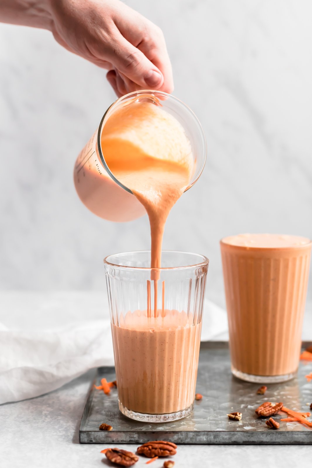 Este delicioso y saludable batido de pastel de zanahoria está hecho con ingredientes saludables como zanahorias crudas, plátanos, piña, leche de coco cremosa, yogur griego y muchas especias reconfortantes. ¡Este batido de pastel de zanahoria repleto de proteínas es el desayuno perfecto o la merienda después del entrenamiento! Vierta un batido de pastel de zanahoria saludable en un vaso