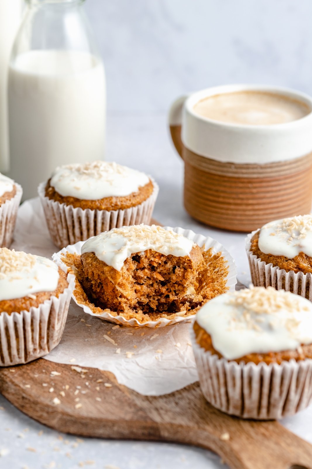 Muffins de pastel de zanahoria saludables rellenos de zanahorias, coco, pasas y nueces. Estos muffins de pastel de zanahoria deliciosamente húmedos están endulzados de forma natural con jarabe de arce puro y compota de manzana. Cubiertos con un glaseado de queso crema ligero, sirva como un refrigerio delicioso o como un saludable ¡merienda! Saque un bocado de muffins de pastel de zanahoria