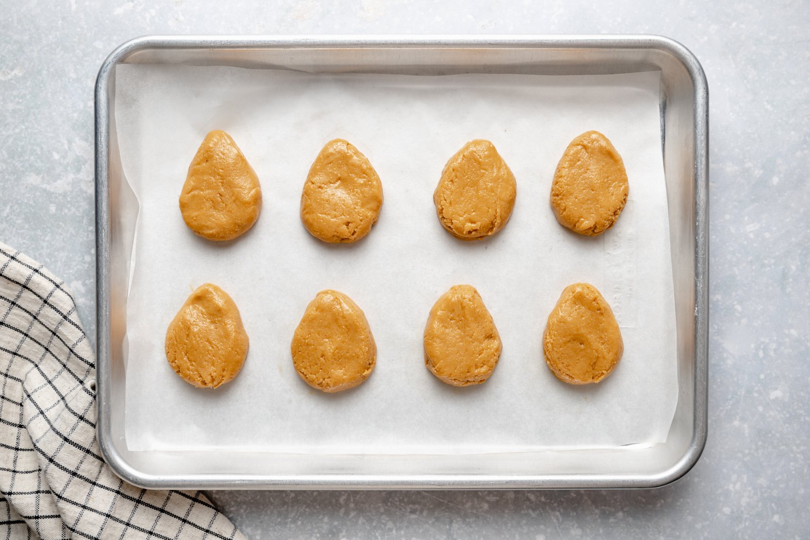 Fáciles y saludables ¡Los huevos de Reese están hechos con solo 4 ingredientes simples! Estos huevos de mantequilla de maní veganos hechos en casa son bajos en carbohidratos, sin gluten, bajos en azúcar y tienen una deliciosa mantequilla de maní en el medio para la comida sin hornear perfecta que a todos les encanta. Huevos veganos de mantequilla de maní en una bandeja