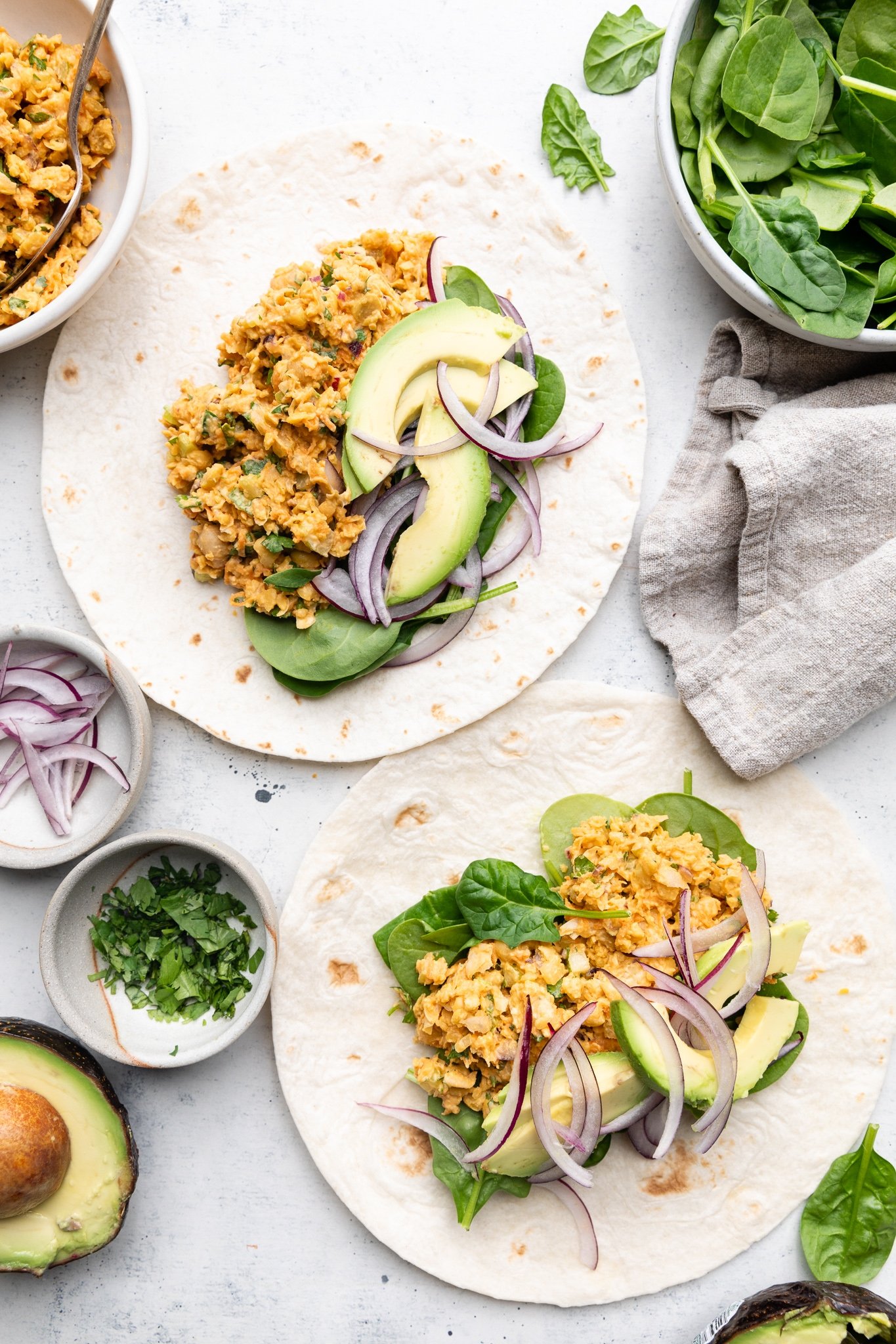 Sabrosos wraps de ensalada de garbanzos estilo buffalo con verduras crujientes, aguacate cremoso y espinacas frescas. Gracias al yogur siggi's y una lata entera de garbanzos, estos sencillos wraps de garbanzos buffalo están repletos de proteínas y son perfectos para los almuerzos empacables entre semana. Ensalada abierta de garbanzos Buffalo envuelta en un plato