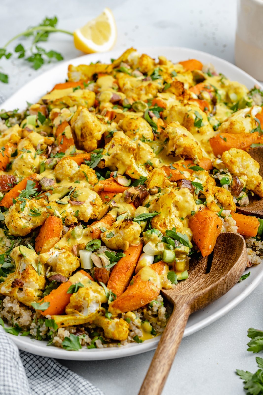 Hermosa ensalada de quinua, coliflor y zanahoria asada con hierbas frescas, deliciosos dátiles y pistachos salados. ¡Esta ensalada vegana de coliflor y quinua con aderezo soleado es el almuerzo o guarnición a base de plantas perfecta! Ensalada vegana de coliflor asada y quinoa con zanahorias en un plato