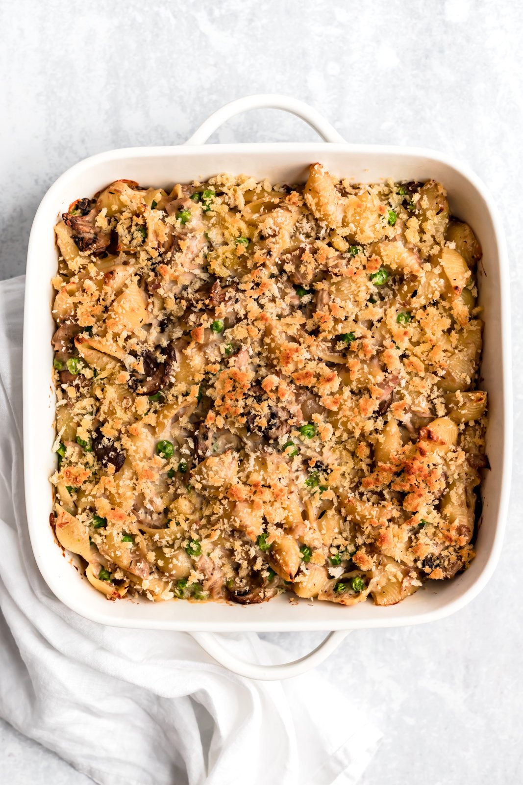 Si está buscando una cazuela de fideos de atún saludable hecha desde cero, ¡no busque más! ¡Esta cazuela ligera de fideos con atún está hecha con una salsa de champiñones parmesano cremosa pero ligera, fideos, atún enlatado y guisantes! ¡Te encantará esta receta fácil para la cena y seguramente se convertirá en tu favorita para siempre! Cazuela de fideos de atún saludable en una sartén