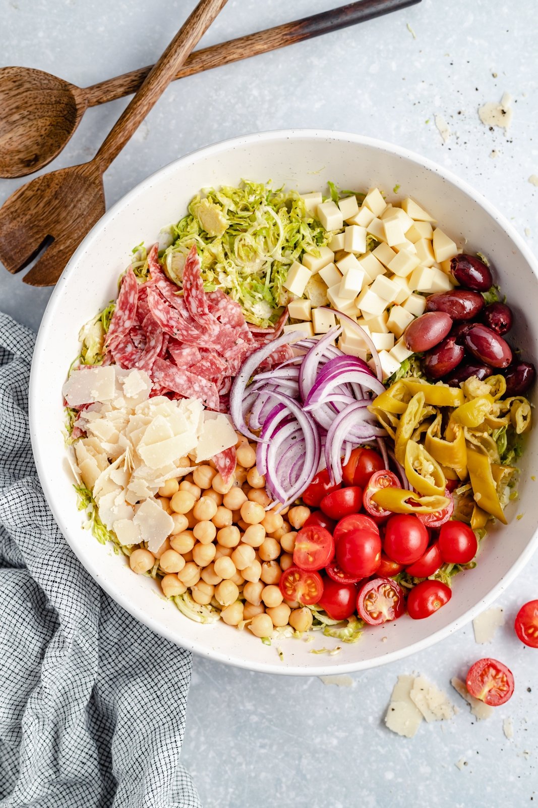 Magnífica receta de ensalada picada italiana con coles de Bruselas ralladas, garbanzos, verduras, salami, aceitunas, pepperoni y delicioso queso. ¡Esta deliciosa y fácil ensalada italiana de coles de Bruselas picadas con un ligero aderezo italiano es el almuerzo abundante perfecto o una cena fresca! Ingredientes para Ensalada Picada Italiana en Tazón