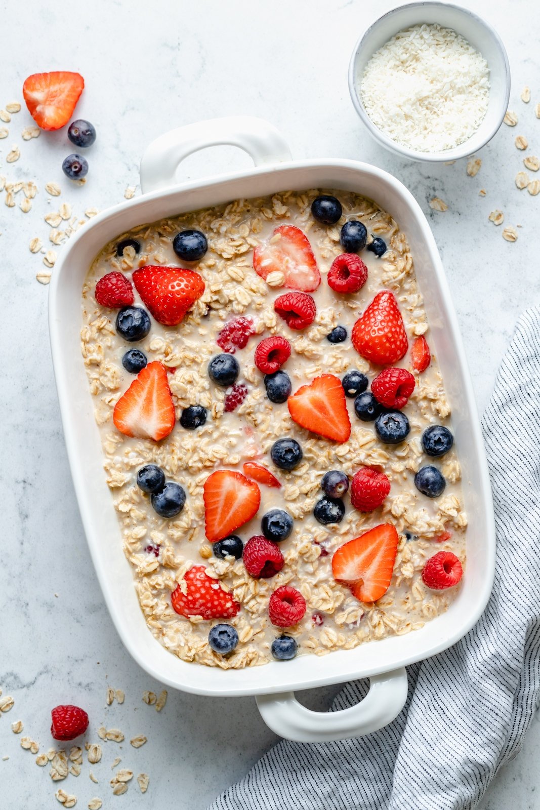 La maravillosa avena horneada con crema y bayas triples está hecha con fresas, arándanos y frambuesas y endulzada de forma natural con un toque de jarabe de arce puro. Esta sencilla receta de avena horneada con bayas presenta grasas saludables en leche de coco cremosa y es la forma perfecta de comer alimentos frescos ¡bayas! Avena horneada en una sartén con bayas sin hornear y crema