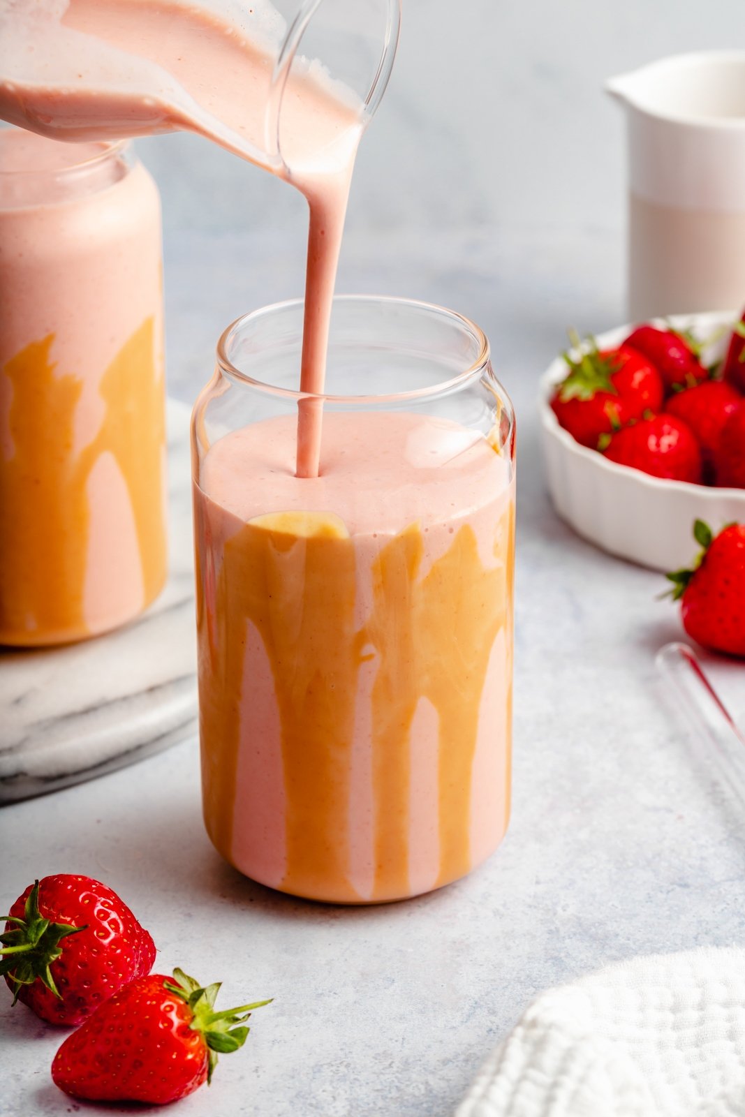 El batido de plátano, fresa y mantequilla de maní más cremoso que te dejará desnudo y delicioso. ¡Solo necesitas 5 minutos y 4 ingredientes simples para hacer este increíble batido con el sabor nostálgico de los plátanos PB&J! Este batido de mantequilla de maní y fresas y plátanos es vegano y está repleto de grasas y proteínas saludables, lo que lo convierte en el desayuno o merienda perfecto. Vierta el batido vegano de plátano, fresa y mantequilla de maní en un vaso