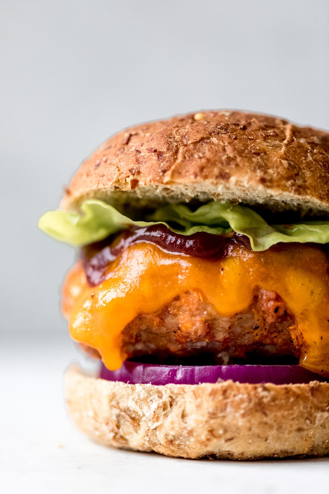 Muy buenas hamburguesas de pollo a la barbacoa con batatas ralladas para mantenerlas jugosas. Cubre estas increíbles hamburguesas de pollo con batatas con una rica y deliciosa salsa BBQ, queso cheddar picante, cebolla morada y lechuga. Esta es la mejor receta saludable de hamburguesa de pollo a la parrilla , perfecto para el verano! Hamburguesas Saludables de Pollo BBQ con Lechuga, Salsa BBQ y Queso