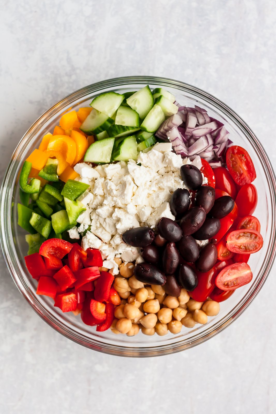 Esta receta fácil de ensalada griega picada toma menos de 20 minutos y está repleta de sabores mediterráneos, vegetales coloridos y proteína vegetal de garbanzos. Te encantará esta ensalada griega de garbanzos porque es rápida y fácil para el almuerzo o para tomar ¡a una fiesta! Ingredientes para Ensalada Griega Picada en un Tazón