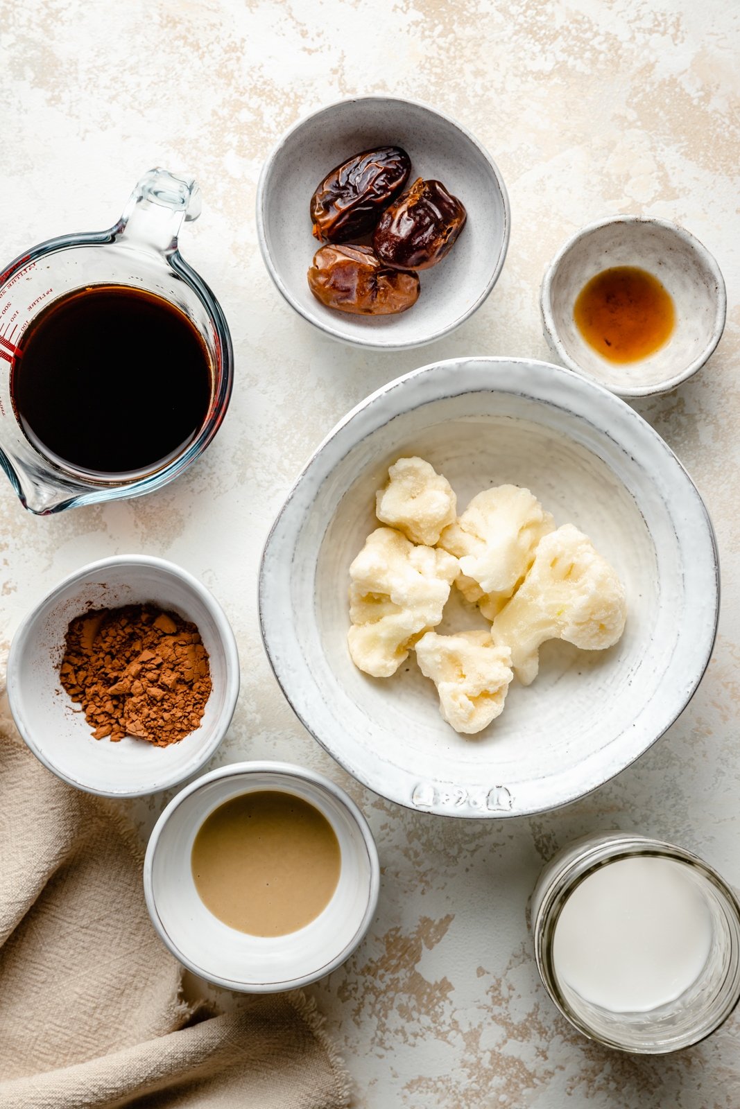 El batido de café con dátiles y tahini espeso y delicioso está hecho con leche de coco cremosa, endulzada de forma natural con dátiles. Esta receta fácil de batido de café con dátiles tiene un toque de rico sabor a cacao y chocolate e incluso contiene vegetales disimulados. Te encantará este batido por un delicioso desayuno o un refrigerio por la tarde. Ingredientes para batido de café con dátiles en un bol