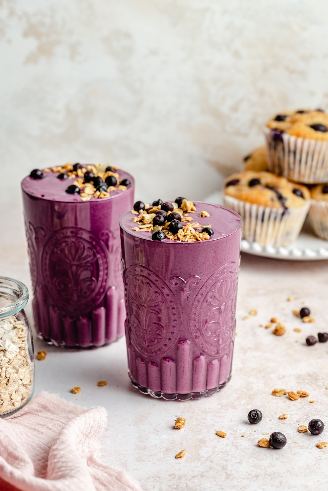 ¡Un batido de arándanos increíble hecho con arándanos silvestres que sabe igual que los muffins de arándanos recién horneados! Este licuado de muffin de arándanos rico en nutrientes es naturalmente dulce sin plátanos, repleto de proteínas de yogur griego y lleno de sabor a muffin gracias a la avena y el lino. ¡Este delicioso desayuno o merienda incluye complementos de sabor opcionales! Dos batidos de arándanos saludables