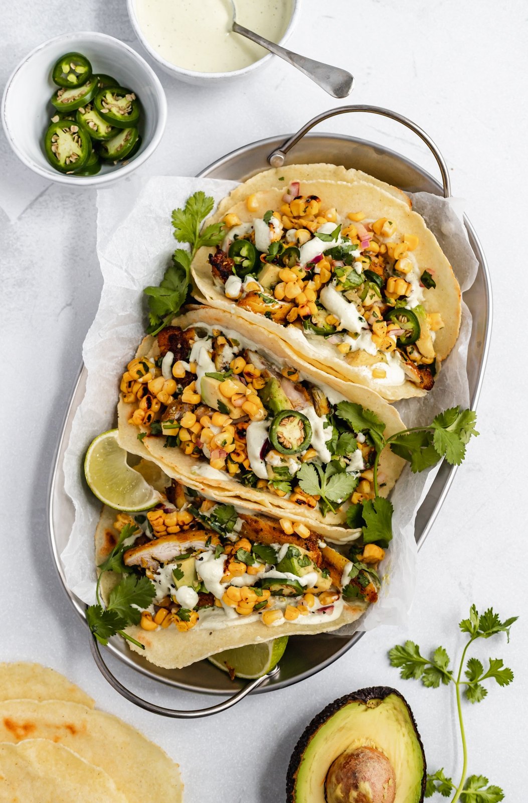 ¡Recetas frescas de temporada para cocinar en junio! Celebre el comienzo de los productos del verano con toneladas de deliciosas ensaladas, recetas a la parrilla y muchos refrigerios. ¡Estas recetas de temporada son perfectas para picnics, comidas compartidas y barbacoas en el patio trasero! Tres tacos saludables de pollo con maíz callejero en una canasta