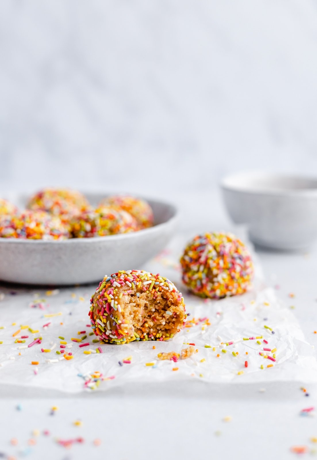 ¡No hornee picaduras de energía de masa de galleta de pastel de cumpleaños que saben igual que la masa de pastel! Hechos con siete ingredientes simples, estos refrigerios veganos energéticos fáciles de pastel de cumpleaños están endulzados naturalmente con jarabe de arce puro y rellenos con chispas festivas. ¡El tentempié o tentempié repleto de proteínas perfecto! Las bolas de proteína de pastel de cumpleaños se sacan de un bocado