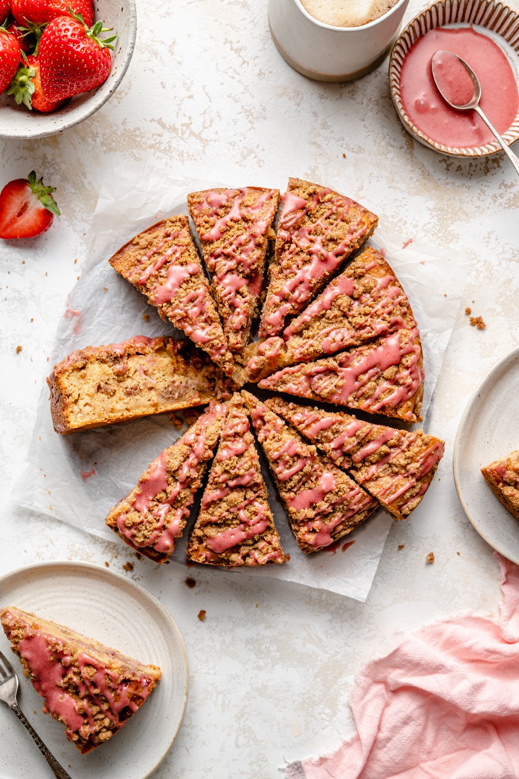 Un hermoso pastel de café con fresas hecho con rica mantequilla marrón y cubierto con un hermoso glaseado de fresas. Esta maravillosa receta de pastel de café con fresas es deliciosa con la miga perfecta encima. ¡La mejor manera de usar fresas frescas durante todo el verano! Pastel de café con fresas y mantequilla marrón en rodajas sobre pergamino