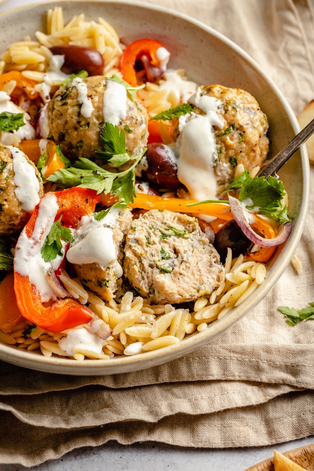 Sabrosas albóndigas griegas de pavo con orzo de limón, verduras tiernas y una cremosa salsa de queso feta. Repletas de un montón de deliciosas hierbas, estas saludables albóndigas griegas de pavo a la parrilla son la comida perfecta entre semana repleta de proteínas. Albóndigas de pavo griego con verduras y orzo en un bol