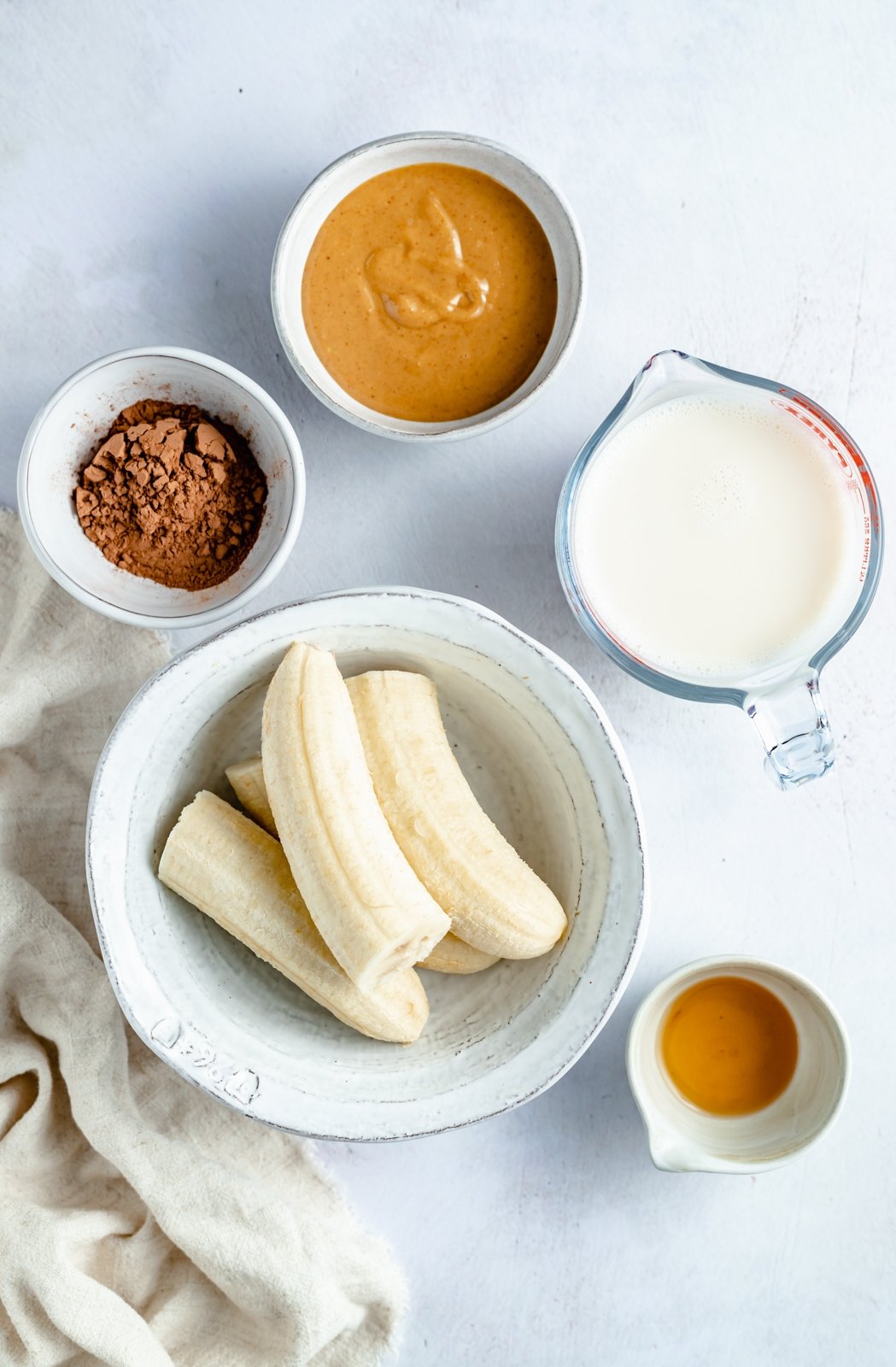 ¡Un delicioso batido cremoso de chocolate con mantequilla de maní y plátano que realmente sabe como el batido de Wendy's! Esta saludable receta de batido de chocolate y plátano está hecha con solo cinco ingredientes y es fácil de usar con su refuerzo nutricional favorito Personalizado. Perfecto para el desayuno, la merienda o incluso el postre ! Ingredientes para batido de plátano y chocolate en un plato