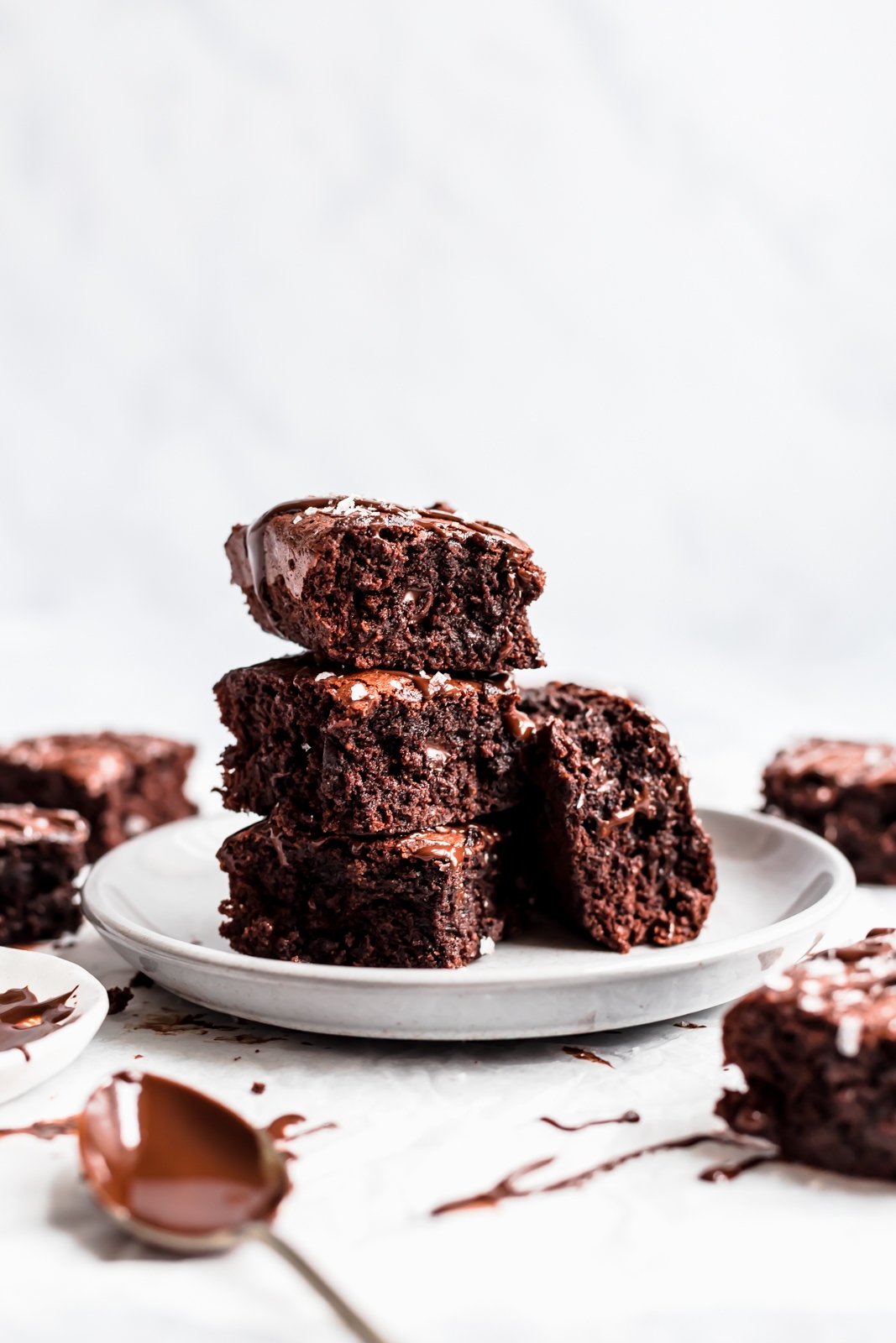 Realmente una de las mejores recetas de brownie sin gluten en Internet: fudge, brownies de mantequilla de almendras sin harina hechos con ingredientes simples como mantequilla de almendras cremosa natural, jarabe de arce puro, cacao en polvo y chispas de chocolate. El horno incluso se calienta directamente del refrigerador increíblemente - ¡te van a encantar! Una pila de brownies de mantequilla de almendras en un plato