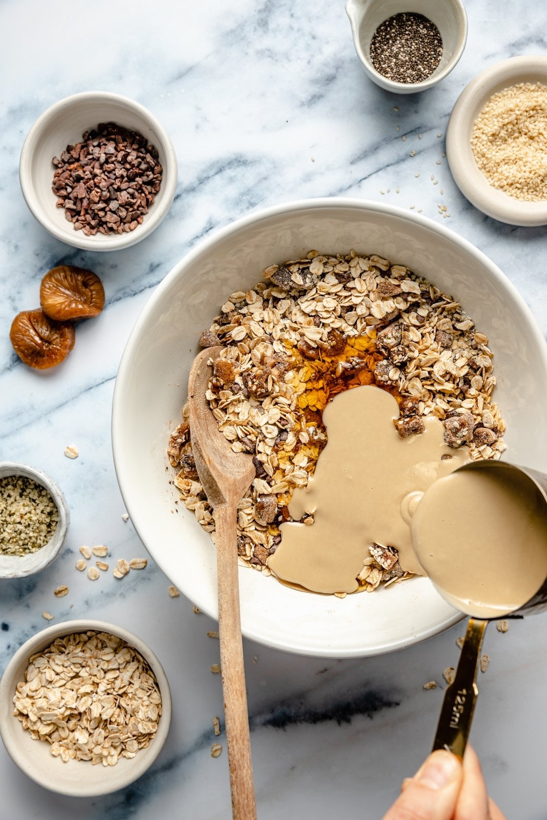 Barras nutritivas de avena con tahini rellenas con semillas de chía, semillas de cáñamo y copos de avena, endulzadas de forma natural con higos secos y miel. Estas sencillas barritas sin hornear están cargadas de fibra y proteína para mantenerte lleno y satisfecho. Rocía con un delicioso chocolate y ¡disfruta de la merienda perfecta o delicia recién sacada de la nevera!” src= mezclar ingredientes para barras de avena con tahini