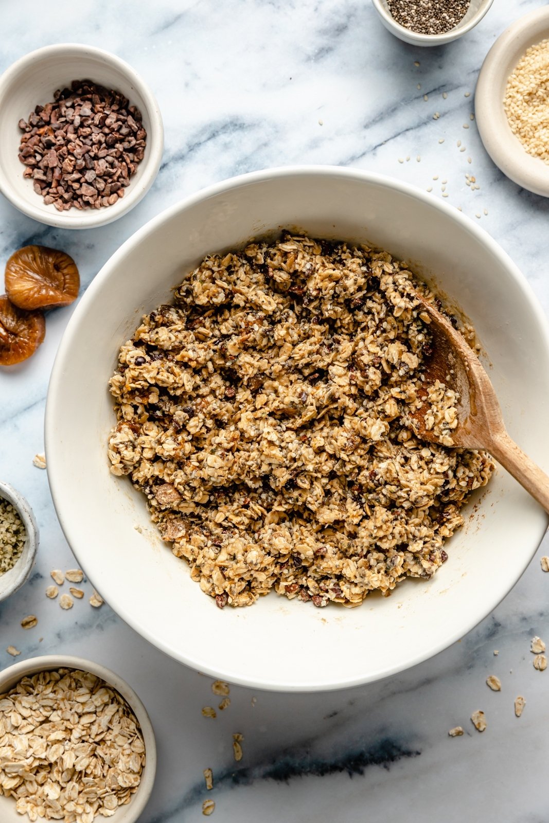 Barras nutritivas de avena con tahini rellenas con semillas de chía, semillas de cáñamo y copos de avena, endulzadas de forma natural con higos secos y miel. Estas sencillas barritas sin hornear están cargadas de fibra y proteína para mantenerte lleno y satisfecho. Rocía con un delicioso chocolate y ¡disfruta de la merienda perfecta o delicia recién sacada de la nevera!” src= Ingredientes para barras de avena mixta con higos en un bol