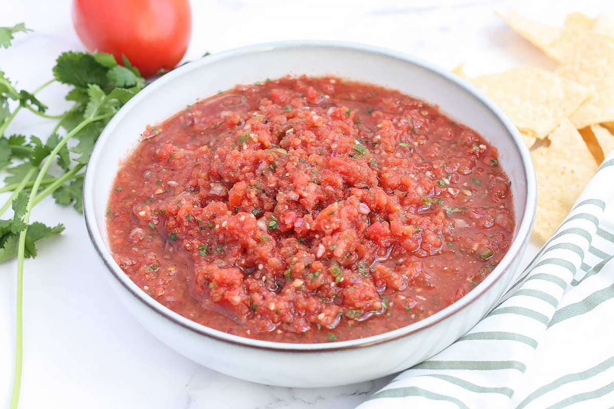 plato de porción de salsa casera con tomates y cilantro