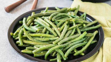 close up image of seasoned cooked green beans on a plate