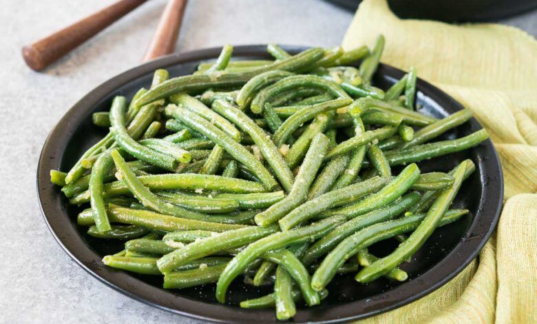 close up image of seasoned cooked green beans on a plate