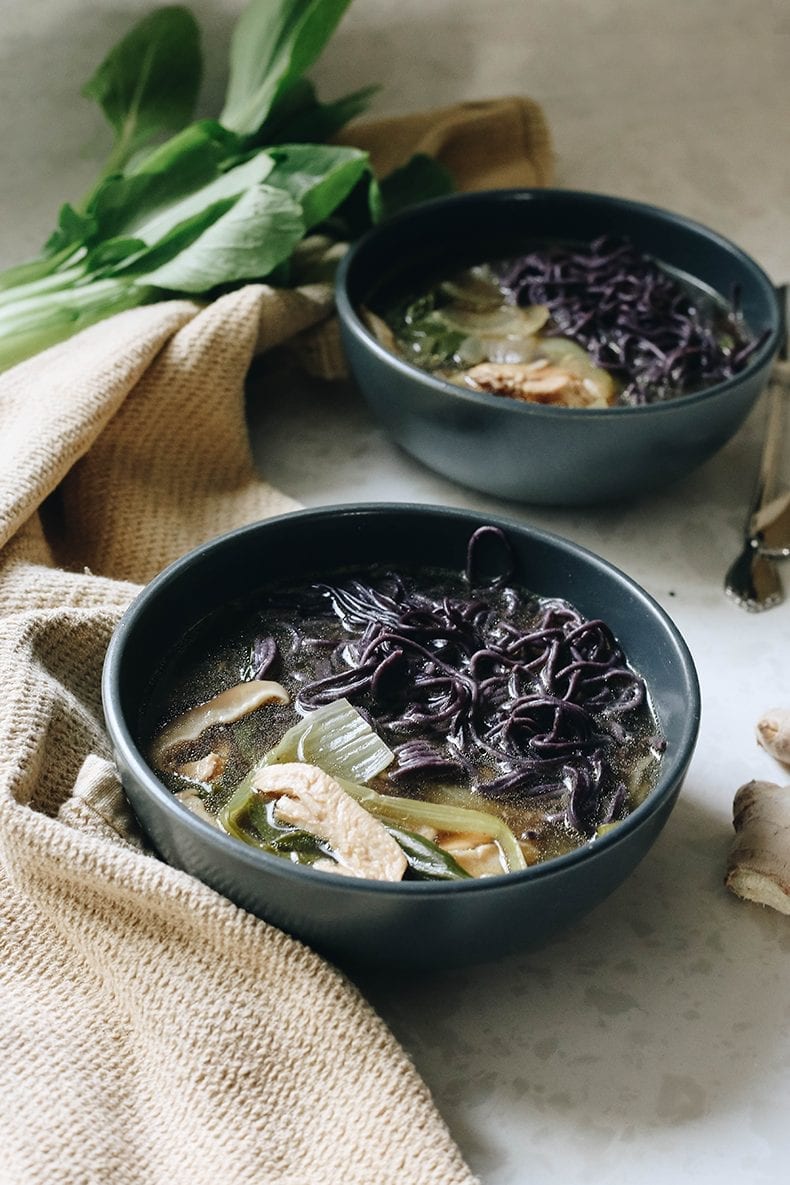 Dos tazones de sopa curativa con fideos, champiñones y verduras. 