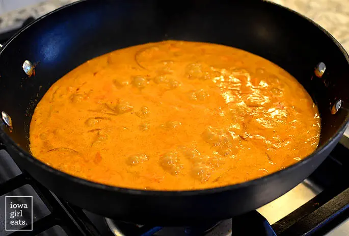 Burbujeante curry tailandés de coco y maní en un wok