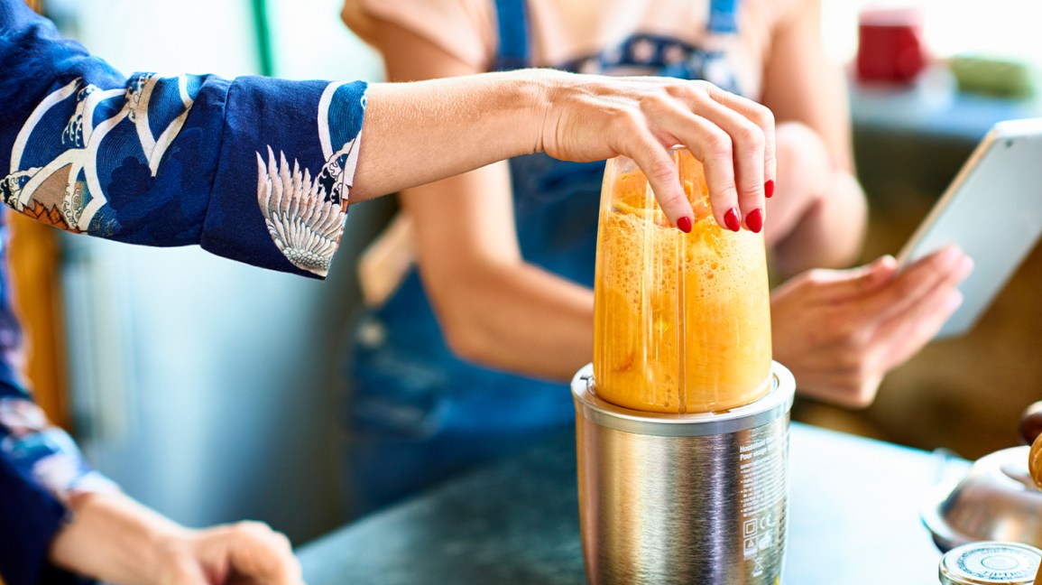 orange smoothie in a hand blender